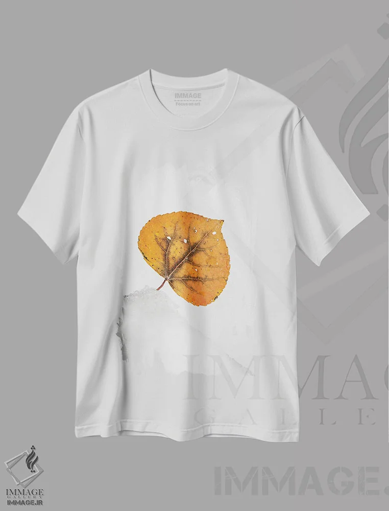 تیشرت سفید طرح دار برگ نارنجی روی تپه برفی، عکاسی ماکرو اثر نیک ریو | immage.ir
