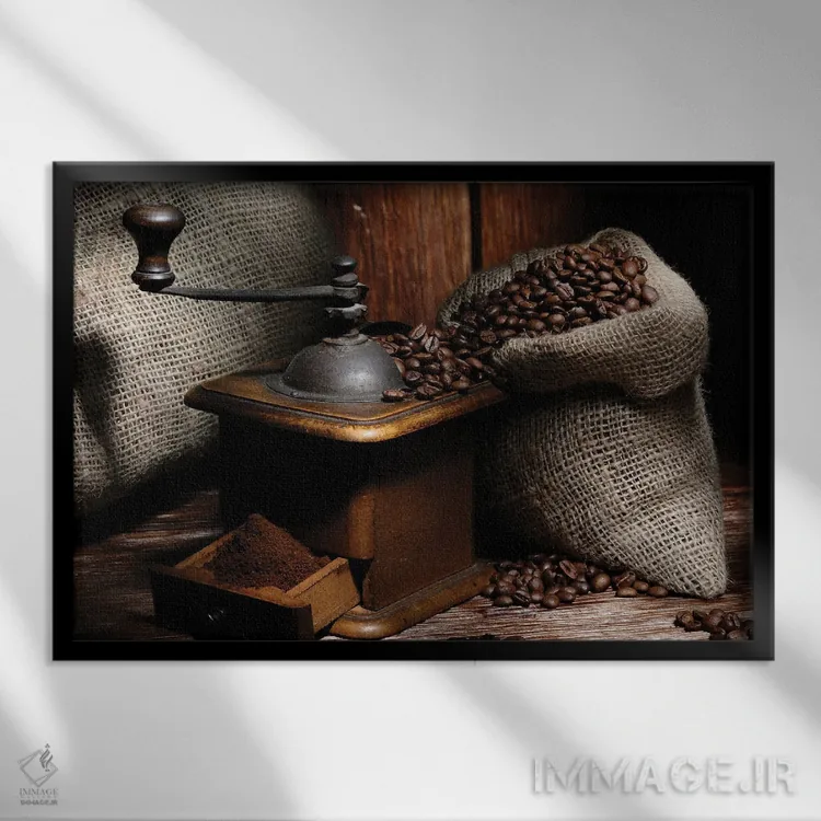 تابلو آسیاب قهوه با دانهها روی میز چوبی اثر آلساندرو دلا توره - نمای قابدار مشکی