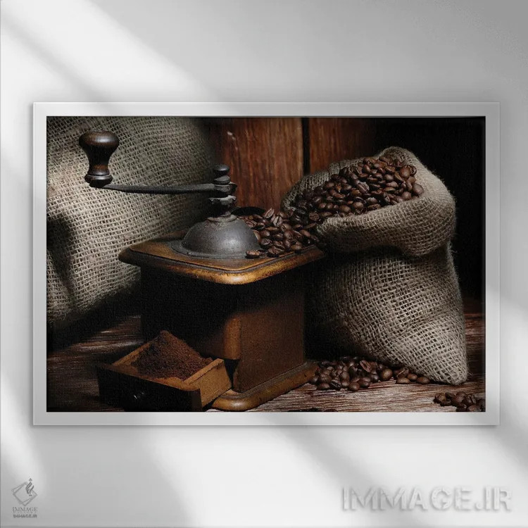 تابلو آسیاب قهوه با دانهها روی میز چوبی اثر آلساندرو دلا توره - نمای قابدار سفید