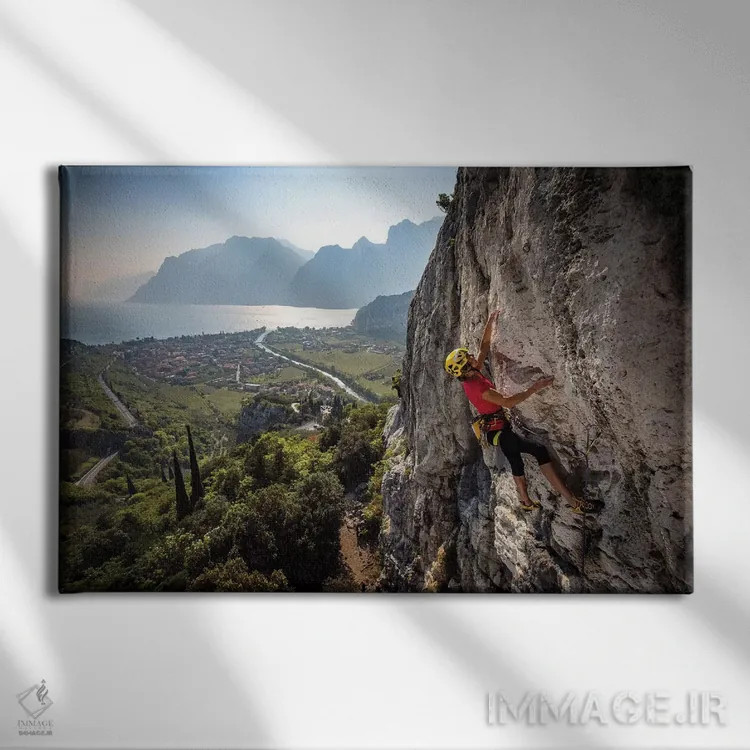 تابلو یک کوهنورد بالای شهر آرکو و دریاچه گاردا، ایتالیا اثر الکس بیوس - نمای روبهرو روی دیوار