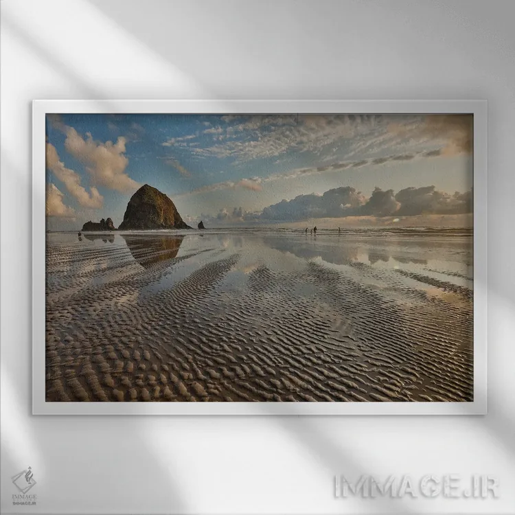 تابلو Oregon, Cannon Beach. Sunset Golden Colors With Ripples In Sandy Beach And The Haystack Rock,آمریکا، اورگن، ساحل کنون. طلوع طلایی همراه با موجهای شن و تختهسنگ هایاستک اثر دارل گالین - نمای قابدار سفید