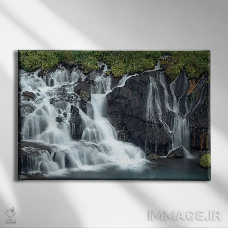 تابلو ایسلند، هراونفوسار. آبشارهای کوچک از دل گدازهها بیرون میآیند و در طول نیممایل وارد رودخانه هویتا میشوند اثر الن گاف - نمای روبهرو روی دیوار