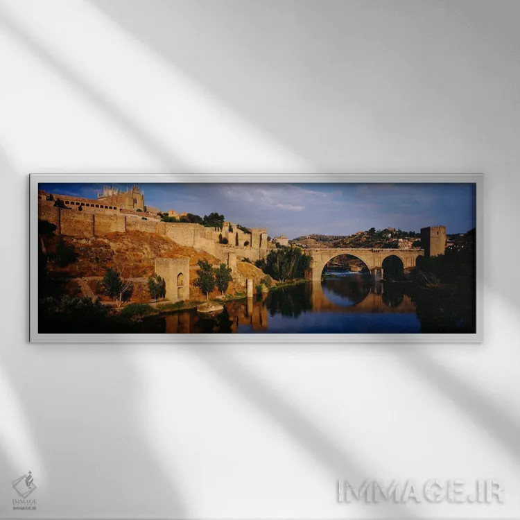 تابلو Toledo, Spain" - "منظره تاریخی در کنار رودخانه ریو تاجو با پل سن مارتین، تولدو، اسپانیا" اثر پانورامیک ایمجز (استودیو عکاسی عریض) - نمای قابدار سفید