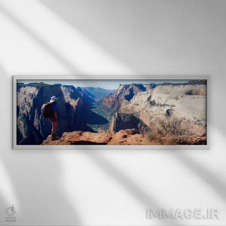تابلو Washington County, Utah, USA,زن کوهنورد ایستاده کنار یک دره، پارک ملی زایون، شهرستان واشینگتن، یوتا، آمریکا اثر پانورامیک ایمجز (استودیو عکاسی عریض) - نمای قابدار سفید