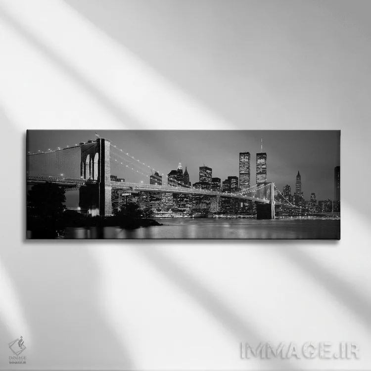تابلو "پل بروکلین روشن شده با نمای افق منطقه مالی منهتن در پسزمینه به صورت سیاه و سفید، نیویورک سیتی، ایالات نیویورک" اثر پانورامیک ایمجز (استودیو عکاسی عریض) - نمای روبهرو روی دیوار