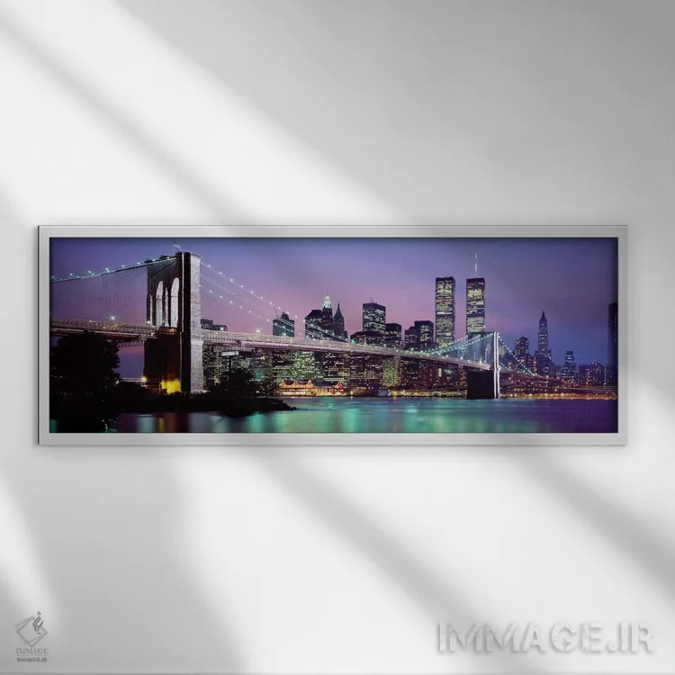 تابلو "پل بروکلین روشن شده با نمای افق منطقه مالی منهتن در پسزمینه، نیویورک سیتی، ایالت نیویورک" اثر پانورامیک ایمجز (استودیو عکاسی عریض) - نمای قابدار سفید