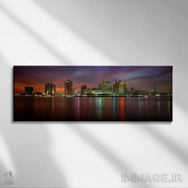 تابلو New Orleans, Louisiana, USA,ساختمانهای روشنشده در کنار آب، نیواورلئان، لوئیزیانا، آمریکا اثر پانورامیک ایمجز (استودیو عکاسی عریض) - نمای روبهرو روی دیوار