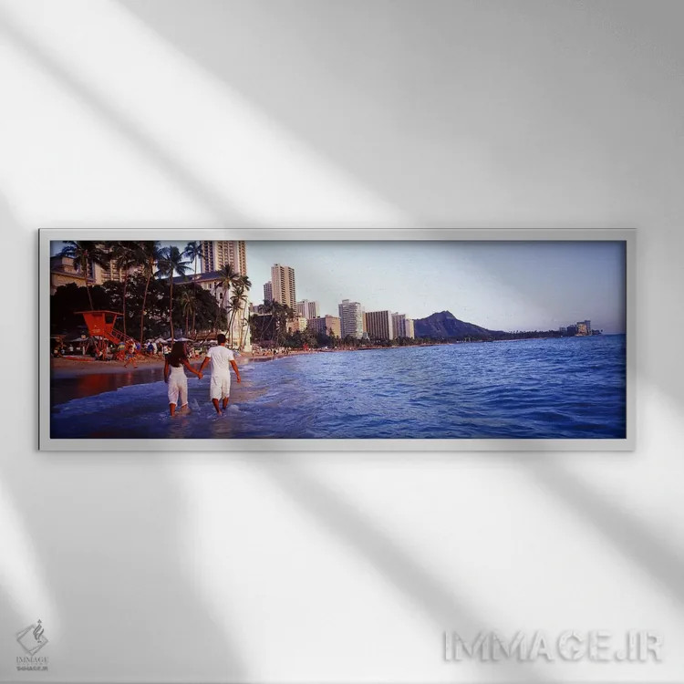 تابلو Waikiki Beach, Honolulu, Oahu, Hawaii, USA,نمای پشت یک زوج در آب راه میروند، ساحل وایکیکی، هونولولو، اوآهو، هاوایی، آمریکا اثر پانورامیک ایمجز (استودیو عکاسی عریض) - نمای قابدار سفید