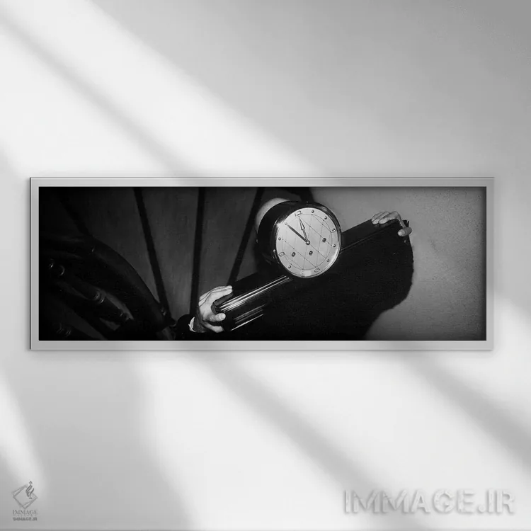 تابلو مردی که ساعت را روی شانه از پلهها بالا میبرد اثر پانورامیک ایمجز (استودیو عکاسی عریض) - نمای قابدار سفید