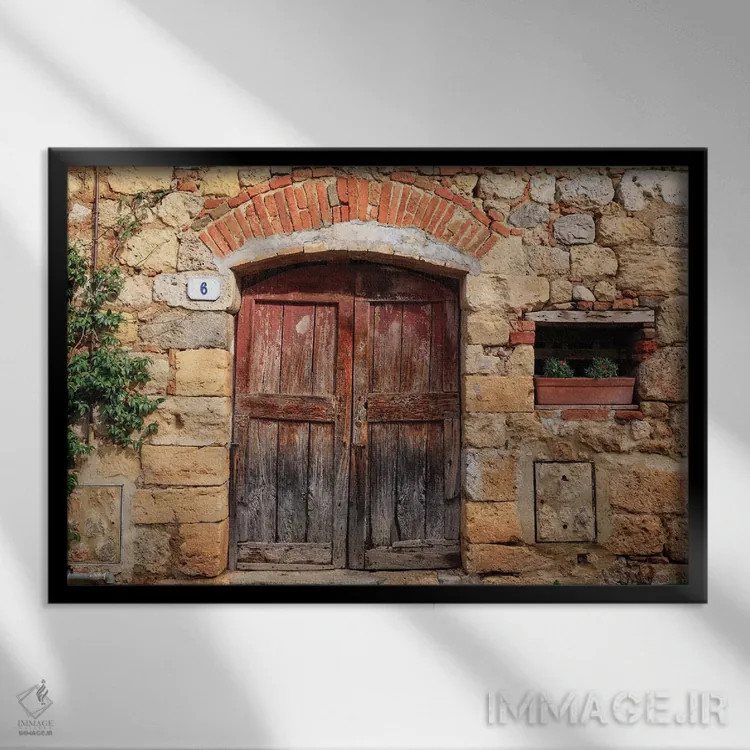 تابلو ایتالیا، مونتریجیونی. دیوار سنگی، در چوبی با شمعدانیهای کاشتهشده اثر امیلی ویلسون - نمای قابدار مشکی