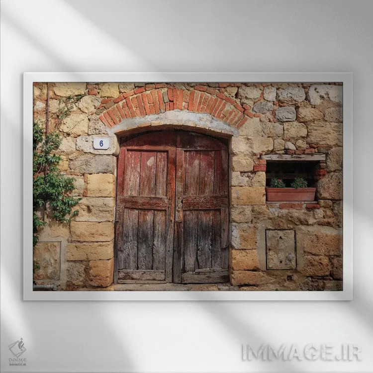 تابلو ایتالیا، مونتریجیونی. دیوار سنگی، در چوبی با شمعدانیهای کاشتهشده اثر امیلی ویلسون - نمای قابدار سفید