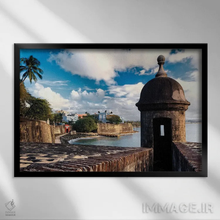 تابلو دکوراتیو نمای دیوارهای سن خوان قدیمی با برج نگهبانی در پیش زمینه، پورت… اثر جورج اوزه - نمای قابدار مشکی