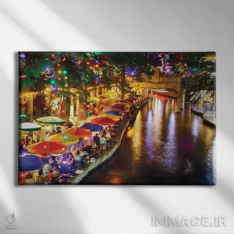 تابلو دکوراتیو قدم زنی کنار رود در شب در کافه ریو، سن آنتونیو، تگزاس، آمریکا اثر جورج اوزه - نمای روبهرو روی دیوار