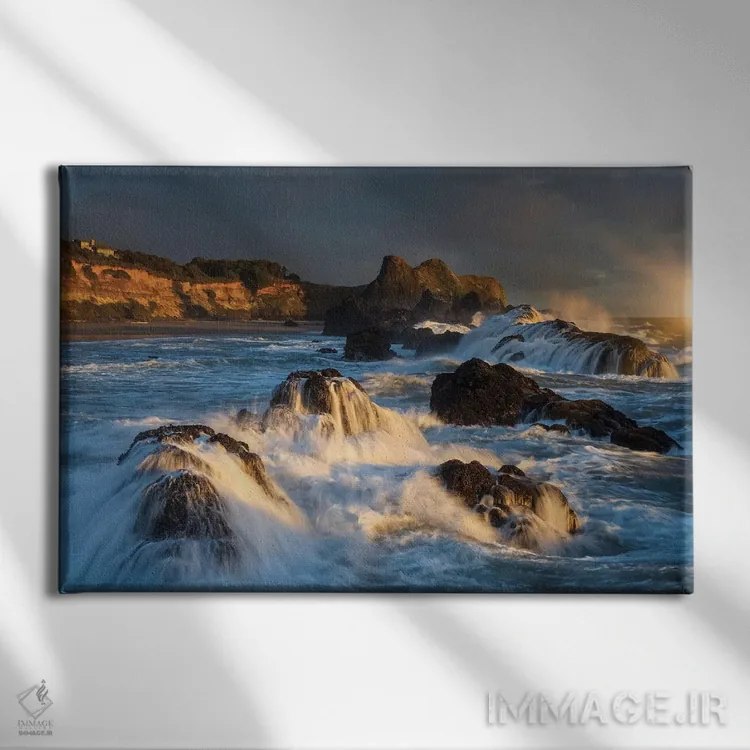 تابلو دکوراتیو امواجی که هنگام غروب به صخره ها برخورد کرده و فرو می ریزند اثر شیلا حداد - نمای روبهرو روی دیوار