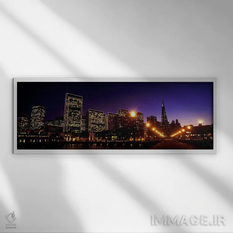 تابلو دکوراتیو ساختمان ها در کنار آب روشن شده در غروب، سانفرانسیسکو، ک… اثر پانورامیک ایمجز - نمای قابدار سفید