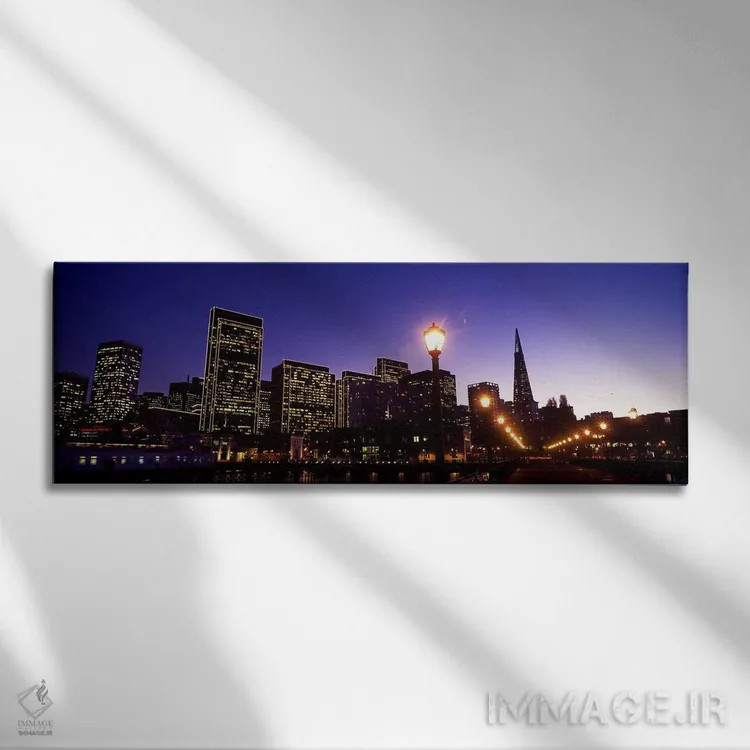 تابلو دکوراتیو ساختمان ها در کنار آب روشن شده در غروب، سانفرانسیسکو، ک… اثر پانورامیک ایمجز - نمای روبهرو روی دیوار