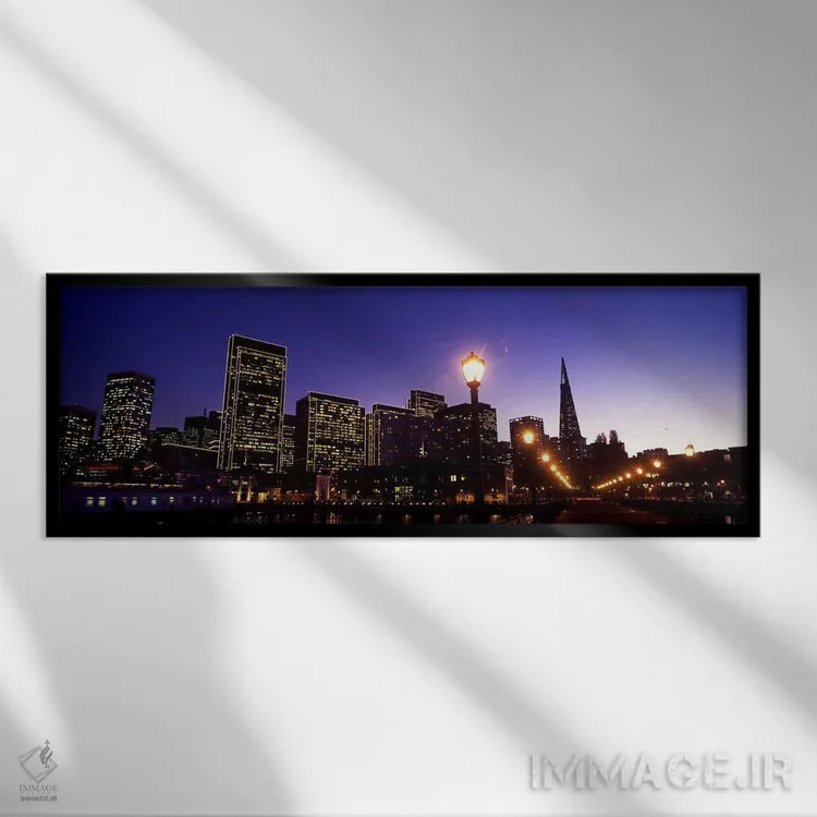 تابلو دکوراتیو ساختمان ها در کنار آب روشن شده در غروب، سانفرانسیسکو، ک… اثر پانورامیک ایمجز - نمای قابدار مشکی