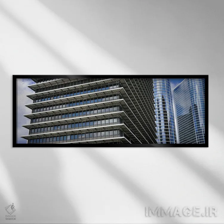 تابلو دکوراتیو نمای پایین از ساختمان ها در یک شهر، ساختمان اکسون موبیل… اثر پانورامیک ایمجز - نمای قابدار مشکی