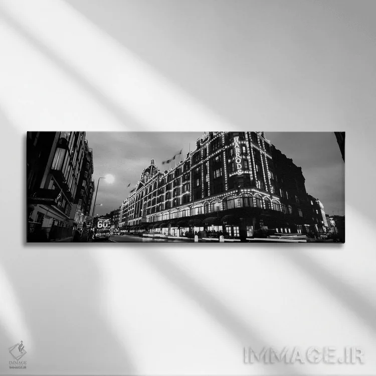 تابلو دکوراتیو "نمای زاویه پایین از ساختمان هایی که شب ها روشن است، ها… اثر پانورامیک ایمجز - نمای روبهرو روی دیوار