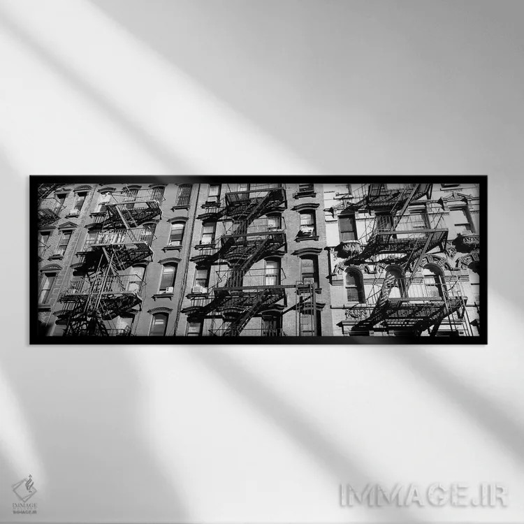 تابلو دکوراتیو "نمای زاویه پایین از نردبان های آتش نشانی روی ساختمان ه… اثر پانورامیک ایمجز - نمای قابدار مشکی