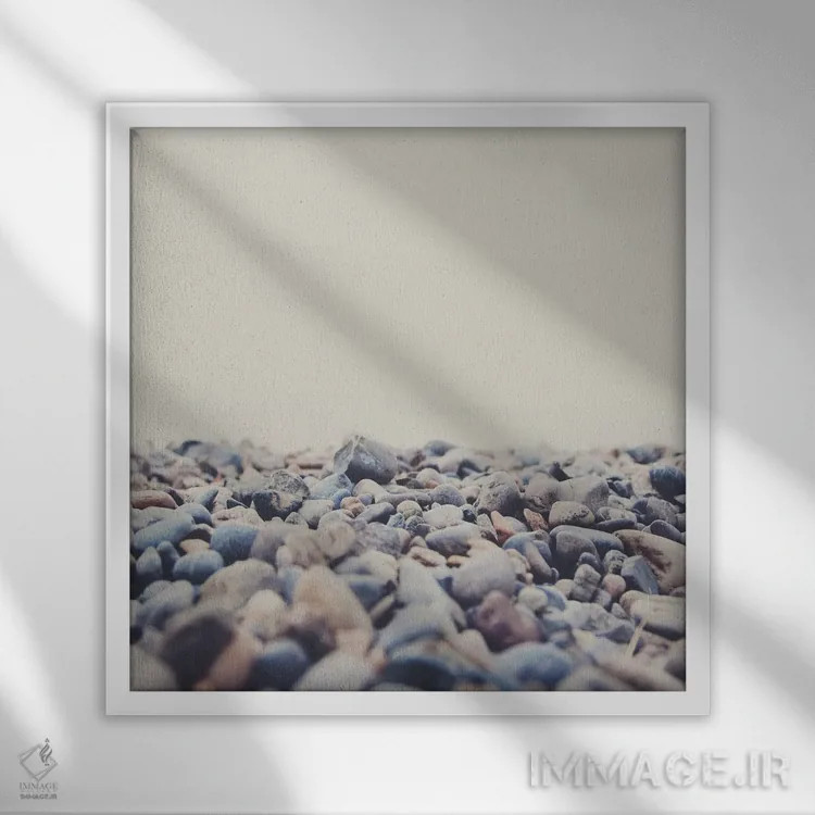 تابلو دکوراتیو سنگ ریزه های ساحل دریاچه کنستانس اثر لورا ایوانز - نمای قابدار سفید