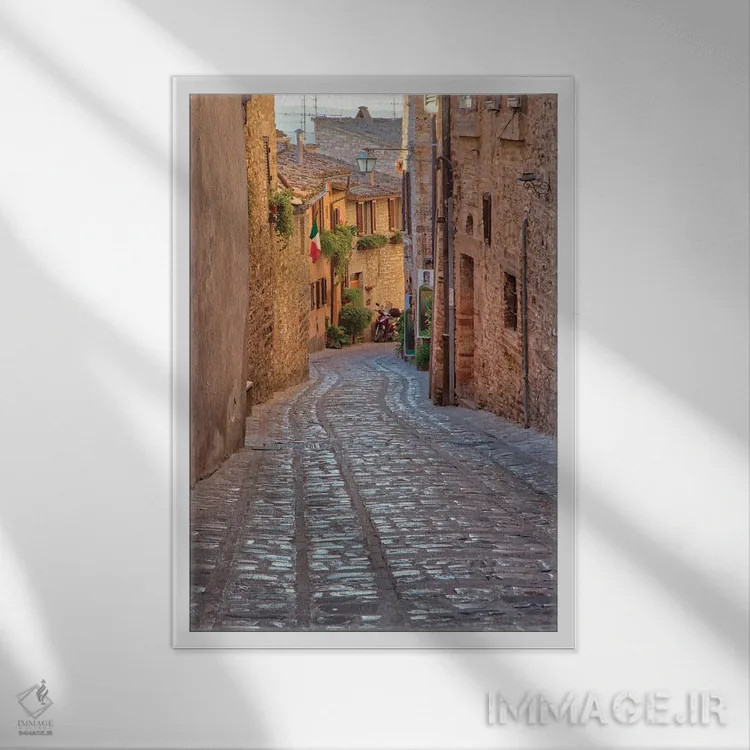تابلو دکوراتیو Umbria Cobblestone Street In The Town Of Spello,ایتالیا، آمبر… اثر جولی اگرز - نمای قابدار سفید