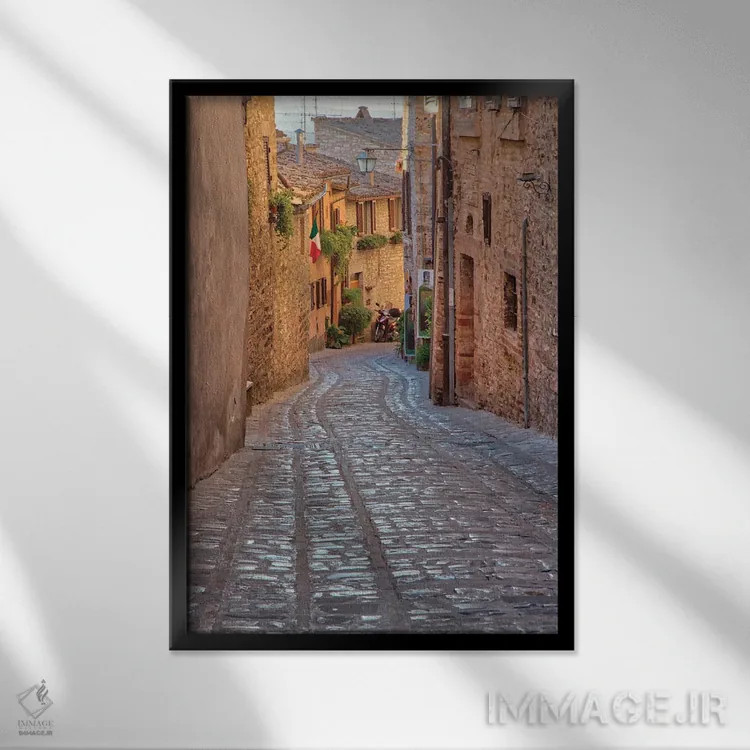تابلو دکوراتیو Umbria Cobblestone Street In The Town Of Spello,ایتالیا، آمبر… اثر جولی اگرز - نمای قابدار مشکی