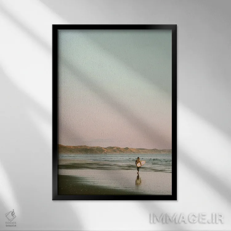 تابلو دکوراتیو موج سوار در حال قدم زدن در ساحل اثر کارن منداو - نمای قابدار مشکی