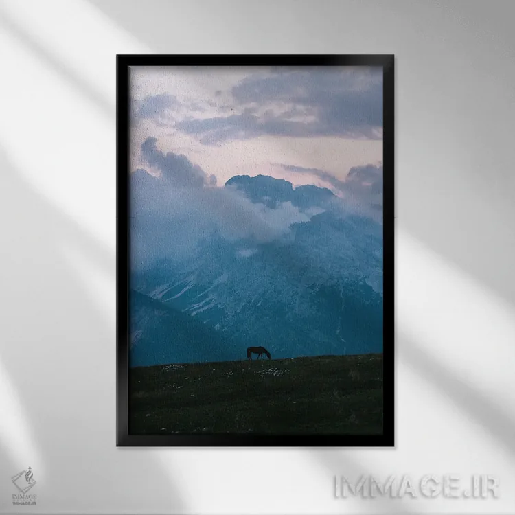 تابلو دکوراتیو اسب تنها در حال چرا در مقابل رشته کوه هنگام ساعت آبی اثر مایکل شاور - نمای قابدار مشکی