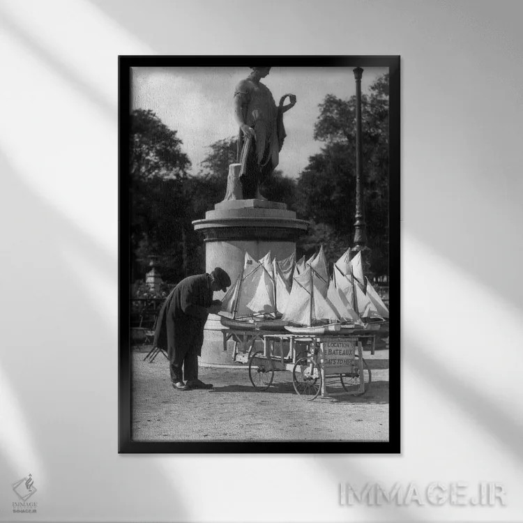 تابلو دکوراتیو دهه ۱۹۳۰ پاریس فرانسه باغ های تویلری مردی با چرخ دستی قایق… اثر تصاویر وینتج - نمای قابدار مشکی