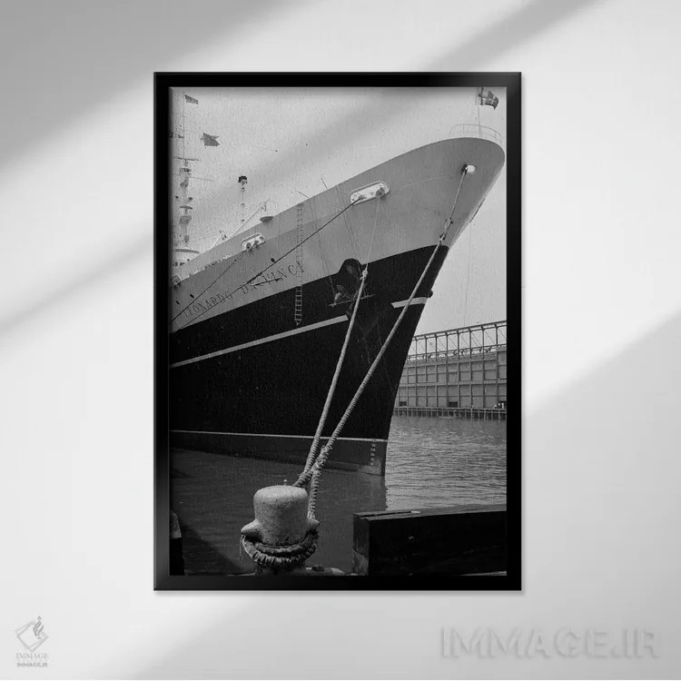 تابلو دکوراتیو قسمت جلویی کشتی لئوناردو داوینچی بسته شده به اسکله و مردی… اثر تصاویر وینتج - نمای قابدار مشکی