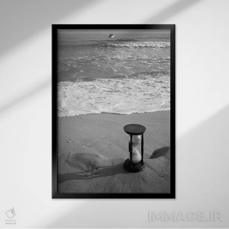 تابلو دکوراتیو طبیعت بی جان ساعت شنی در کنار ساحل با موج ها و قایق تندرو… اثر تصاویر وینتج - نمای قابدار مشکی