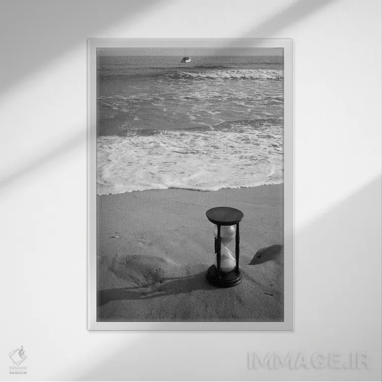 تابلو دکوراتیو طبیعت بی جان ساعت شنی در کنار ساحل با موج ها و قایق تندرو… اثر تصاویر وینتج - نمای قابدار سفید