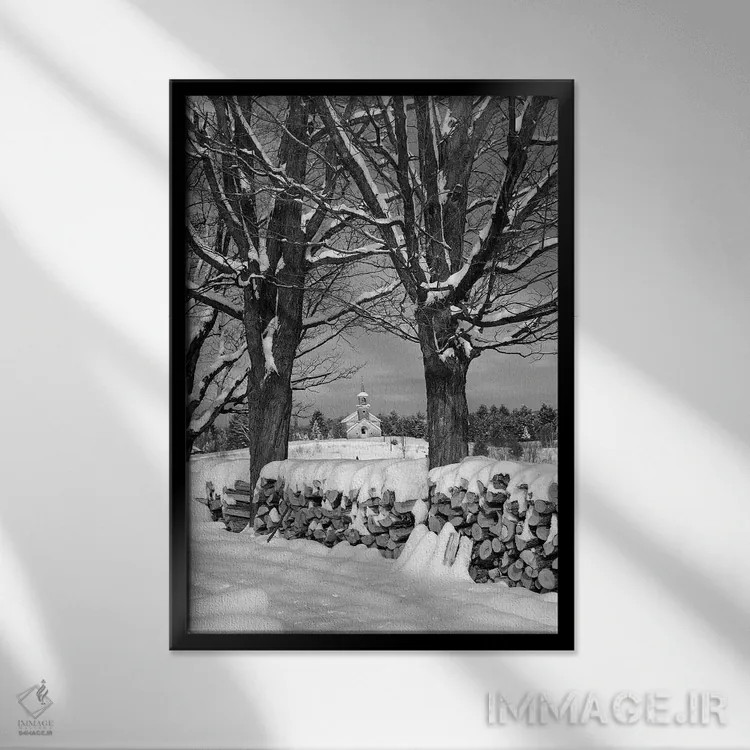 تابلو دکوراتیو توده هیزم پوشیده از برف بین دو درخت با کلیسای روستایی در پ… اثر تصاویر وینتج - نمای قابدار مشکی