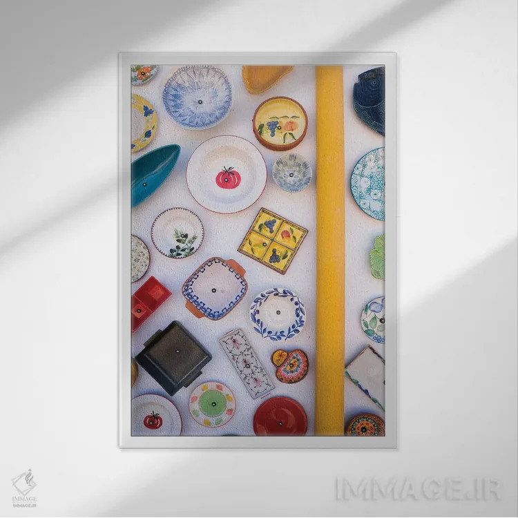 تابلو دکوراتیو بشقاب های رنگارنگ روی دیوار اثر گیلیارد برسسان - نمای قابدار سفید
