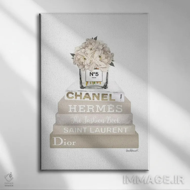 تابلو دکوراتیو Champagne, And Gold Bookstack Topped By Vase With White… اثر آماندا گرینوود - نمای روبهرو روی دیوار